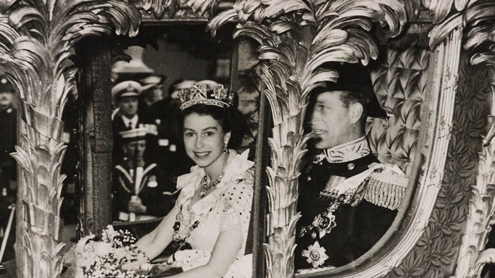 HM Queen Elizabeth II and HRH The Prince Philip, Duke of Edinburgh, en route to the Coronation of Her Majesty, 2 June 1953 Photograph of HM Queen Elizabeth II sitting beside HRH The Prince Philip, Duke of Edinburgh in the Gold State Coach on their way to Westminster Abbey for the Coronation Service. In the background can be seen Naval Officers with rifles and Police