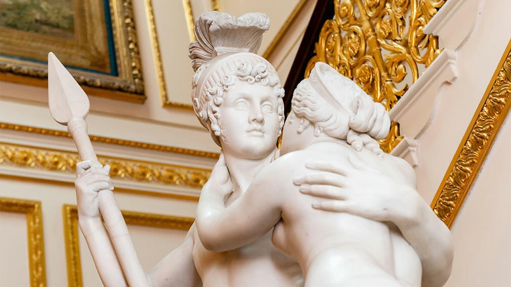 Mars and Venus by Antonio Canova in the Marble Hall (RCIN 2038). Marble statue of two people embracing with backdrop of palace.