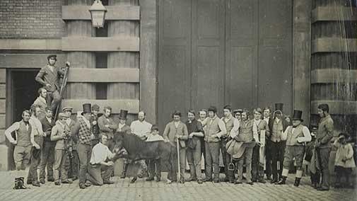 A group of men and children with Webster, the pony, by the main doors of the Royal Mews.