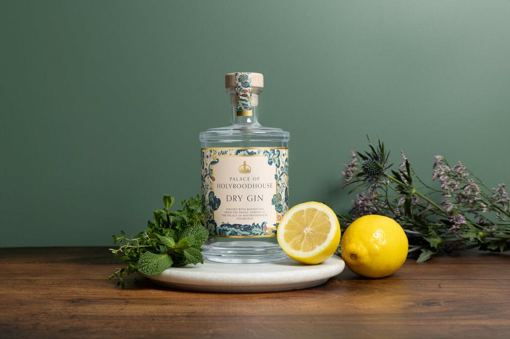 The Palace of Holyroodhouse Dry Gin Photograph of a bottle of the Palace of Holyroodhouse Dry Gin surrounded by fresh lemons and herbs