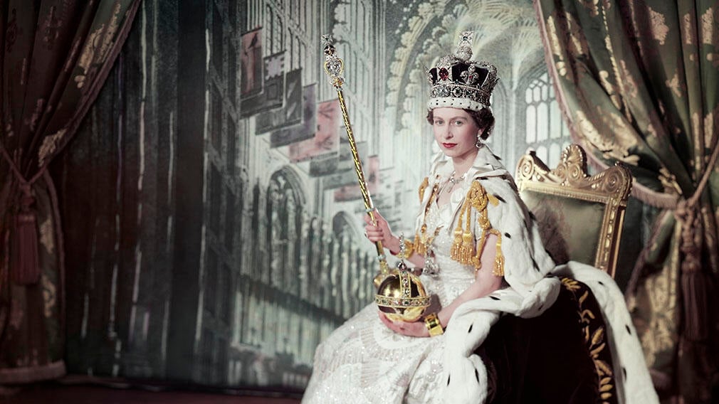 Queen Elizabeth II on her Coronation Day. She is wearing the Imperial State Crown and holds the Sovereign's Sceptre with Cross and Orb. (Portrait by Cecil Beaton RCIN 2153177) Photograph of Queen Elizabeth II seated wearing coronation robes. She poses against a backdrop depicting the interior of Westminster Abbey