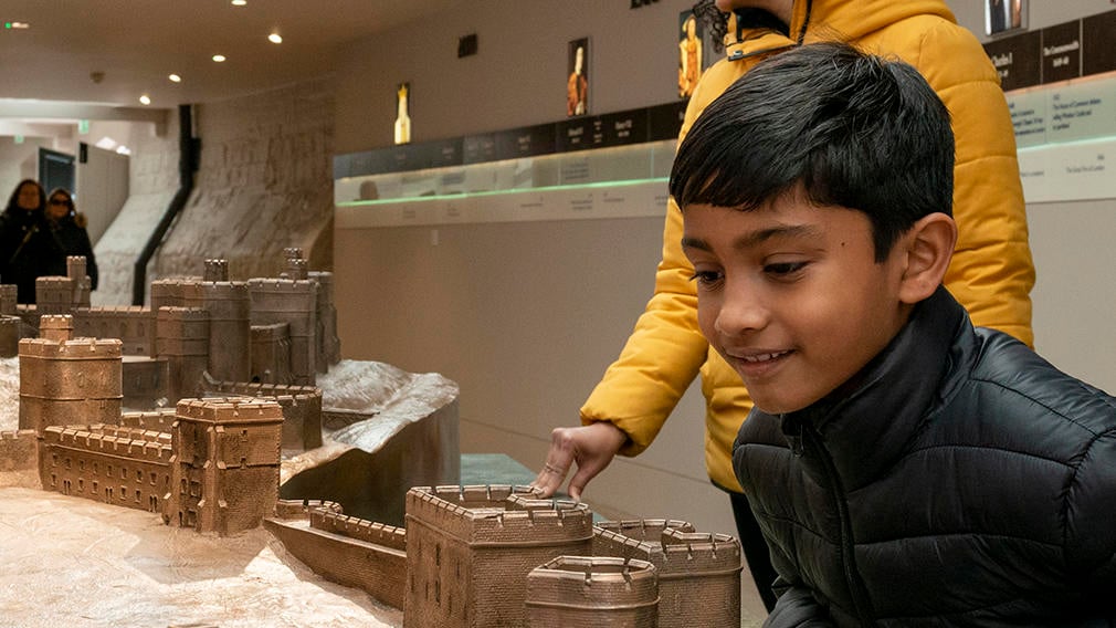 Child enjoying a visit to Windsor Castle A child smiling while looking at a scale model of Windsor Castle