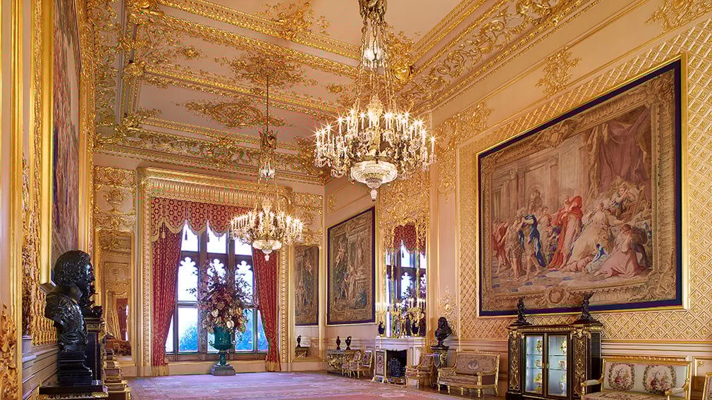 The Grand Reception Room The inside of a ornate room with chandeliers and artwork on the walls