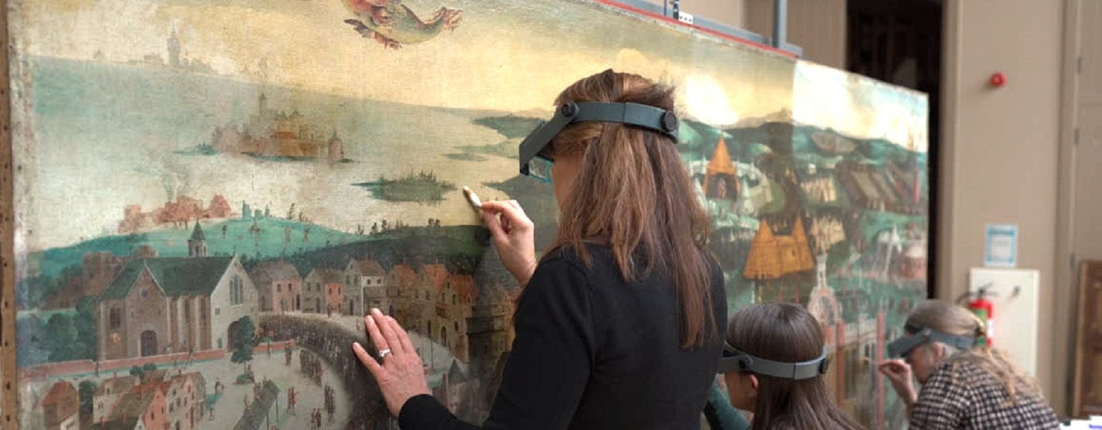Conservators working on The Field of the Cloth of Gold, British School 16th Century